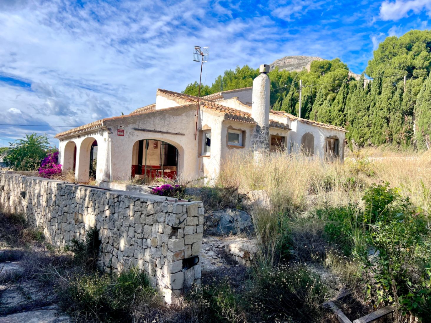 Villa traditionnelle avec naya à arches et cheminée, offrant une vue sur le Montgó. La propriété dispose d'un mur en pierre sèche et nécessite une rénovation complète.