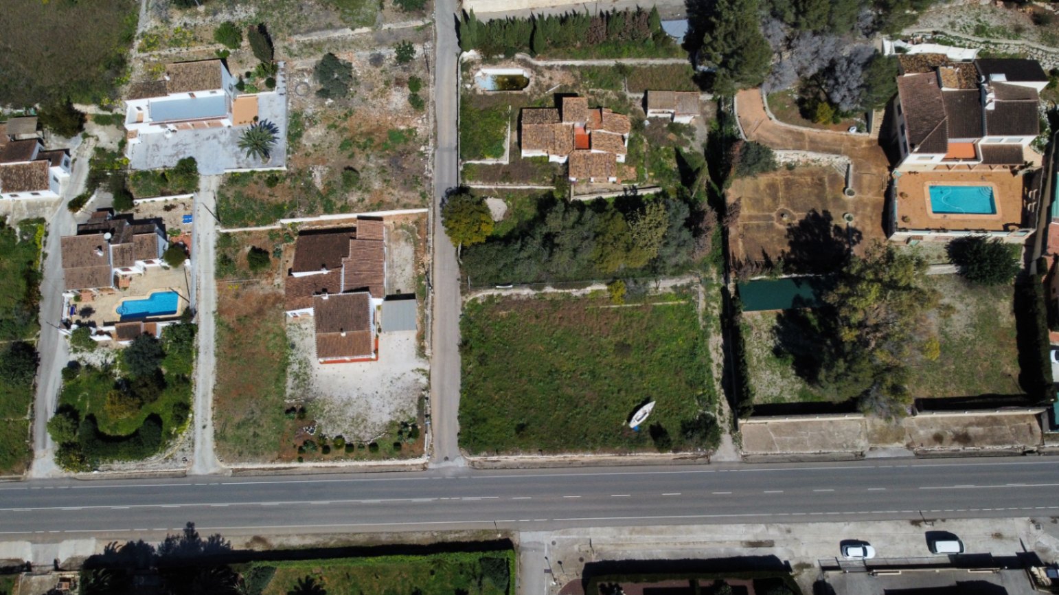 Vue aérienne du terrain de 2 895 m2 à Jávea, illustrant l'emplacement de la villa, l'accès routier et le potentiel d'agrandissement sur cette vaste parcelle orientée sud.