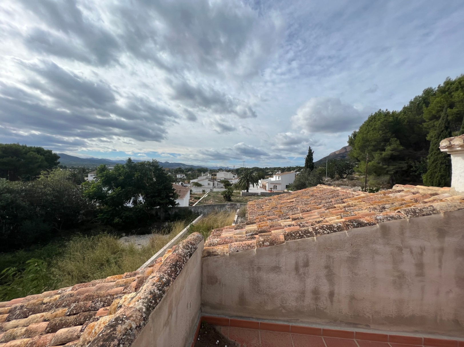 Vues dégagées depuis la terrasse supérieure sur la vallée du Montgó, mettant en valeur les toits en tuiles et l'environnement verdoyant de Jávea.