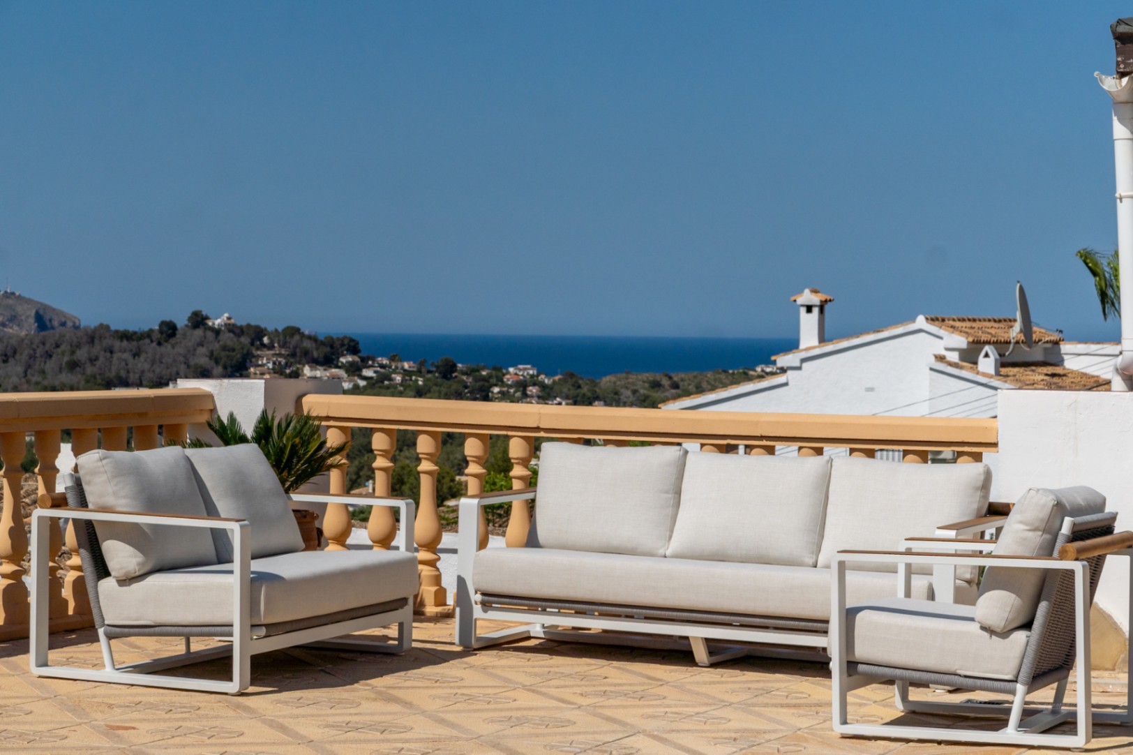 Terrasse surélevée avec mobilier de jardin moderne offrant une vue panoramique sur la mer Méditerranée et le littoral de Jávea.