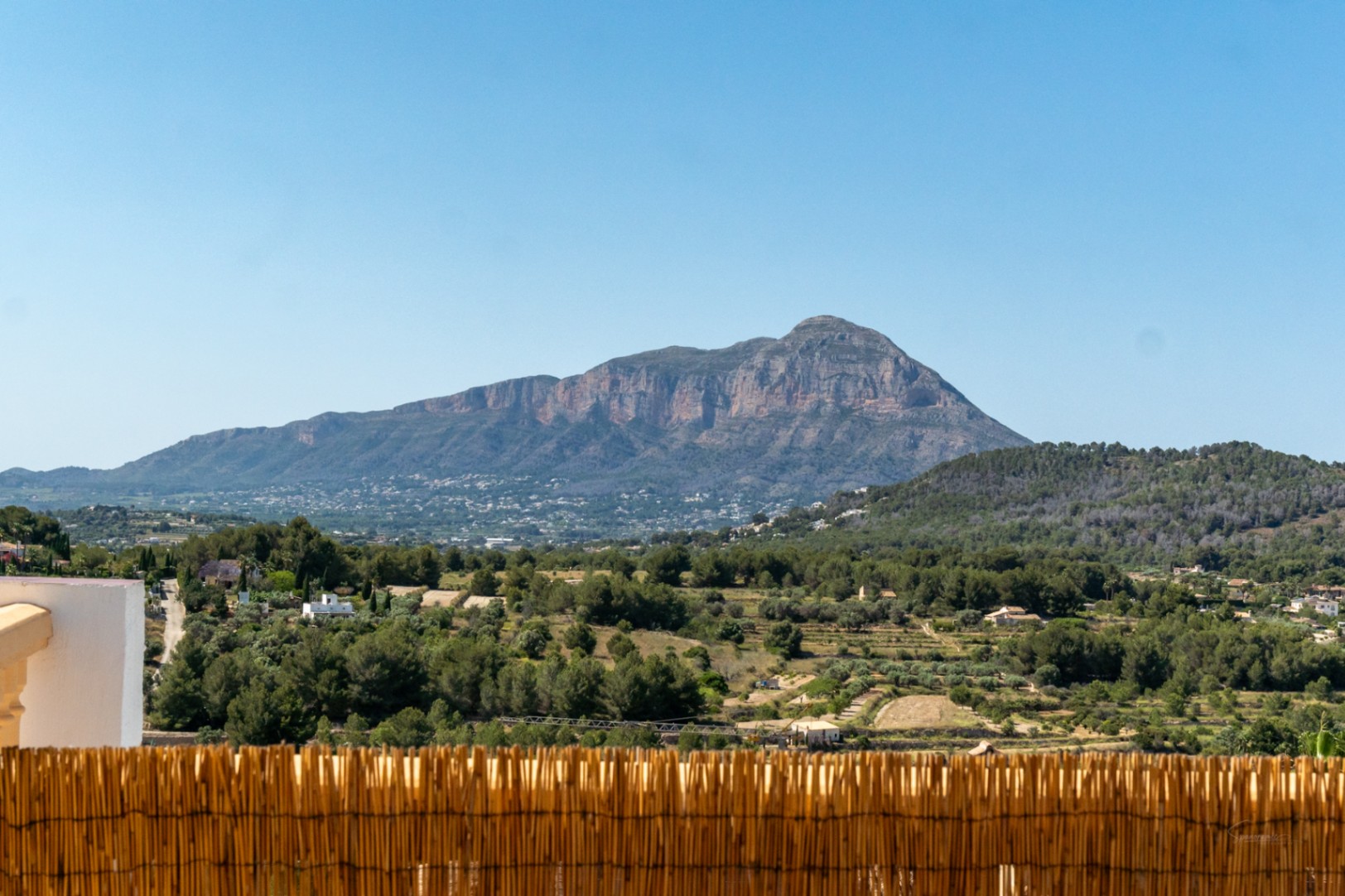 Vues panoramiques frontales sur le massif du Montgó depuis la terrasse, surplombant un paysage méditerranéen de pinèdes sous un ciel dégagé.