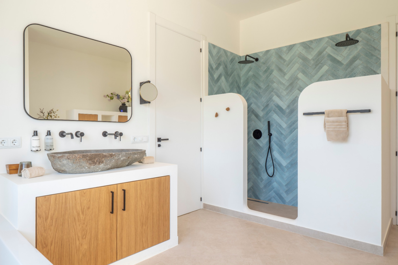 Détail de salle de bain avec lavabo en pierre et douche en chevrons bleus à Jávea Villa.