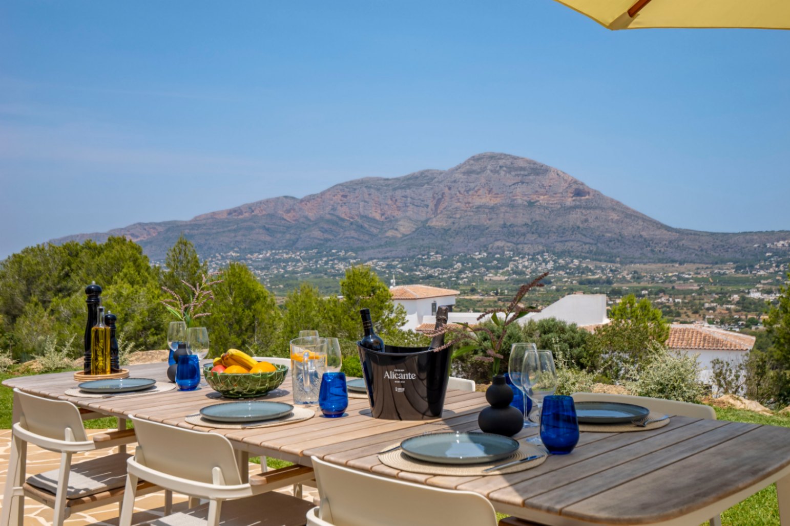 Salle à manger extérieure avec table en bois et vue sur la montagne à Jávea.