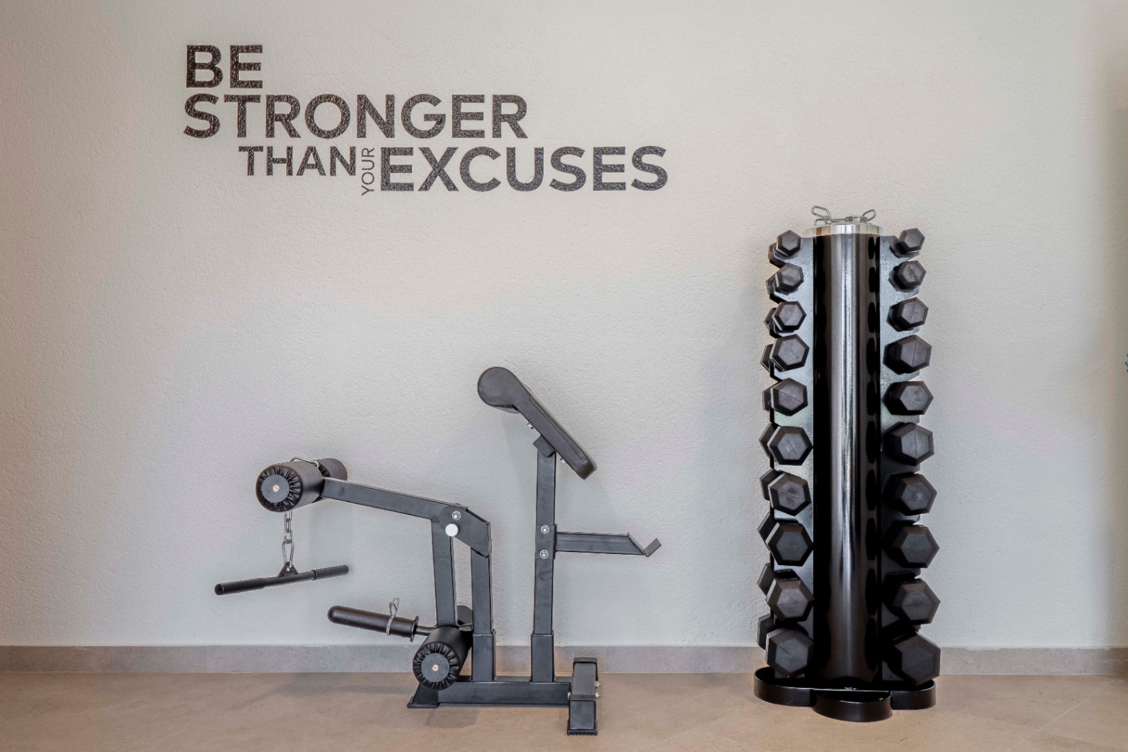 Salle de sport à domicile avec machine d'exercice et support d'haltères hexagonaux noirs.