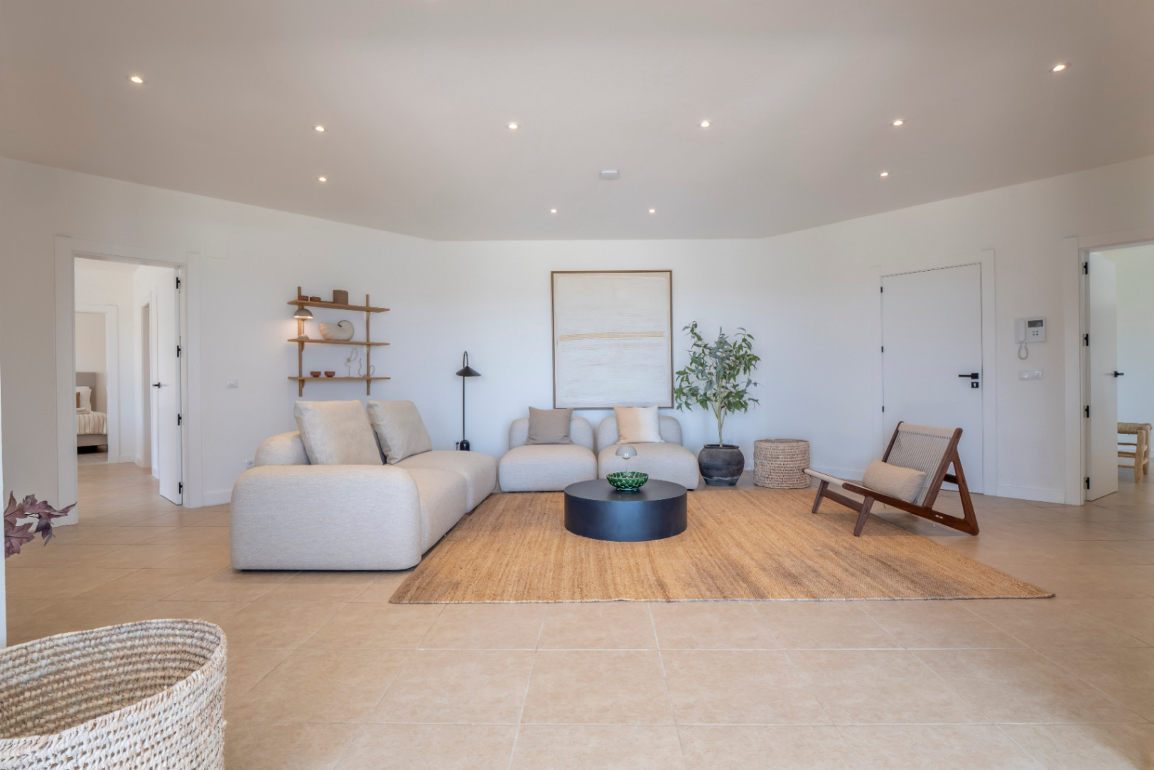 Salon lumineux avec canapé modulable beige, tapis en jute et décor minimaliste. Éclairage encastré.