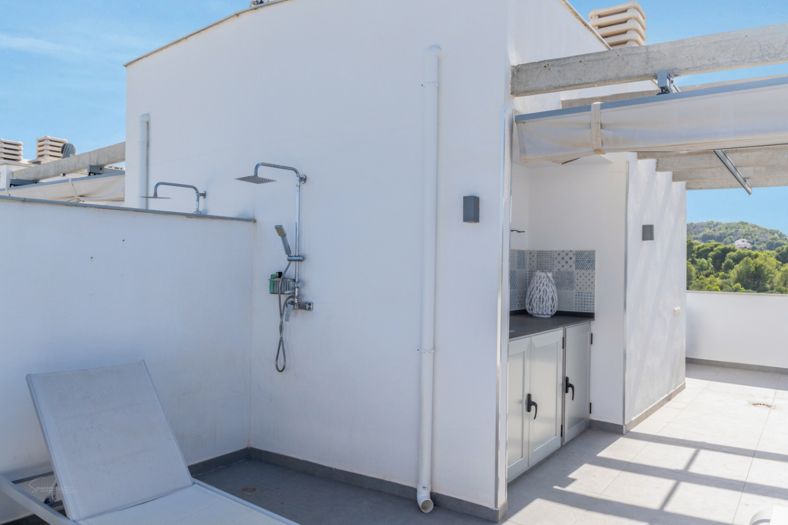 Terrasse privée sur le toit avec douche extérieure, cuisine d'été intégrée et vue sur les collines verdoyantes environnantes.