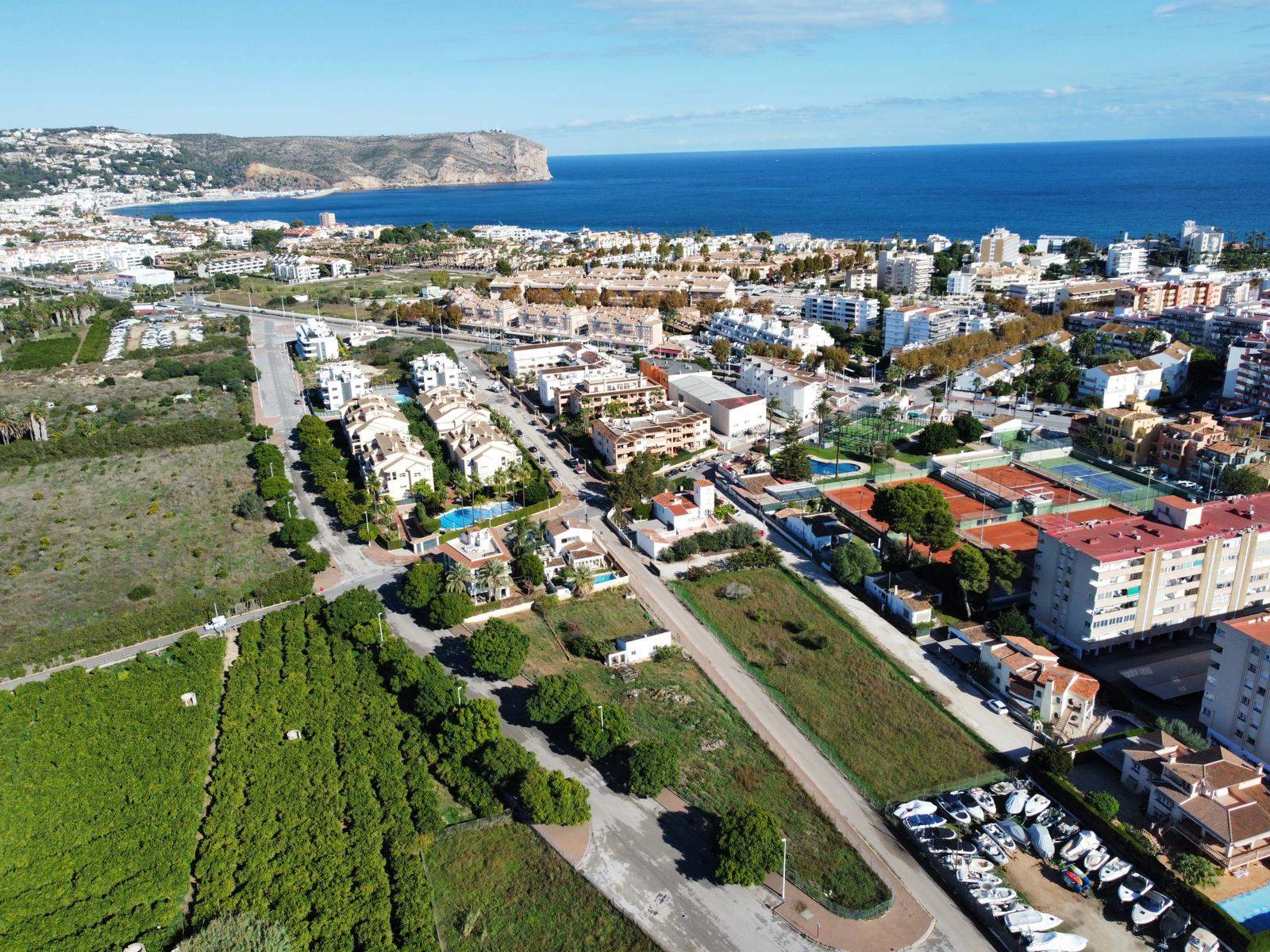 Vue aérienne du terrain à bâtir à Jávea, jouxtant le club de tennis et offrant un panorama sur la mer Méditerranée et les falaises du Cabo de San Antonio.
