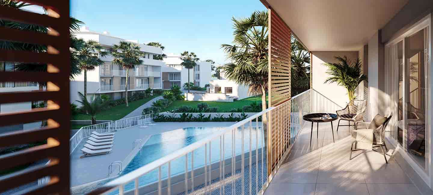 Terrasse privée avec carrelage et mobilier moderne, offrant une vue sur la piscine commune et les jardins méditerranéens paysagers.
