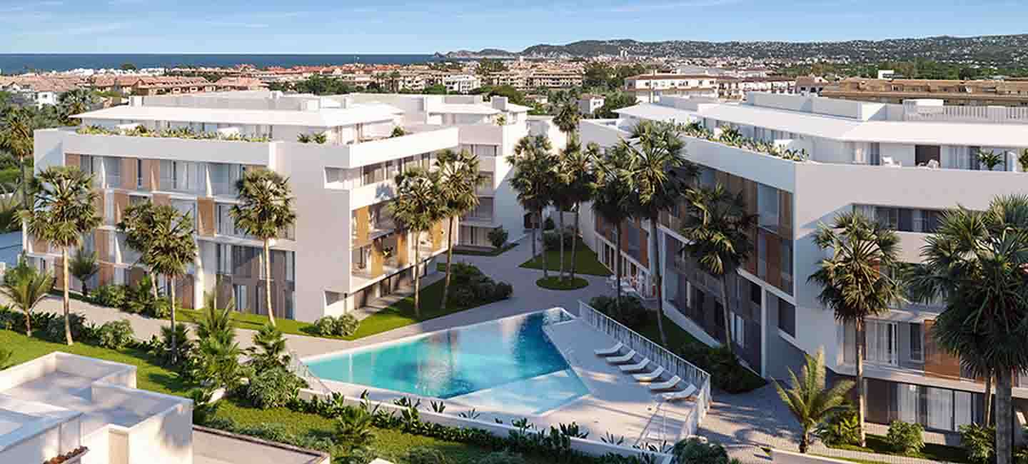 Vue aérienne du complexe d'appartements contemporains avec des bâtiments blancs, des volets en bois, une piscine triangulaire et des jardins paysagers.