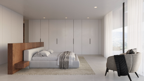 Chambre principale avec tête de lit en bois, placards intégrés toute hauteur et grandes baies vitrées offrant une vue sur le paysage vallonné.