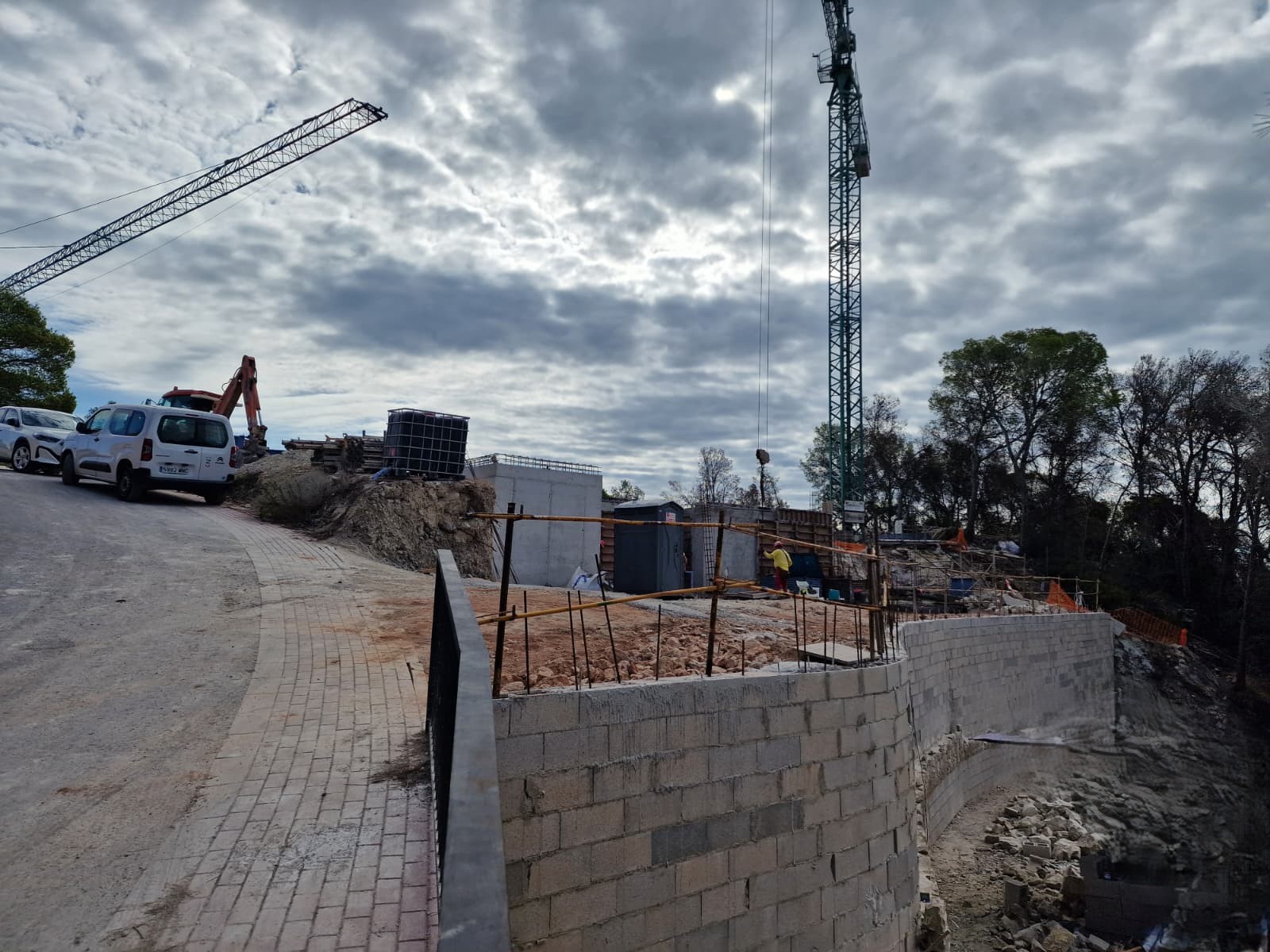 État actuel du chantier à Moraira, montrant les murs de soutènement incurvés, l'accès pavé et les engins de construction pour la phase structurelle initiale.