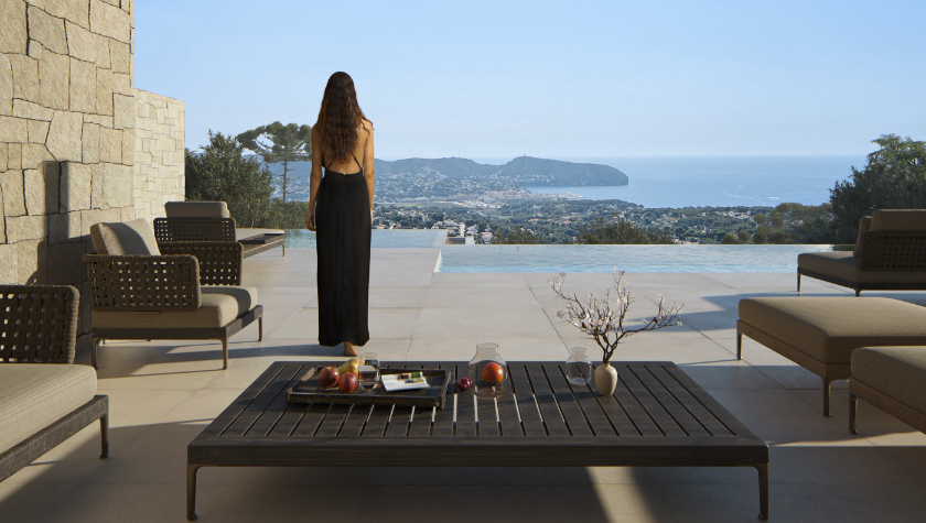 Terrasse avec piscine à débordement et vue panoramique sur la mer. Elle dispose de murs en pierre naturelle, d'un sol en grand format et d'un mobilier d'extérieur design.