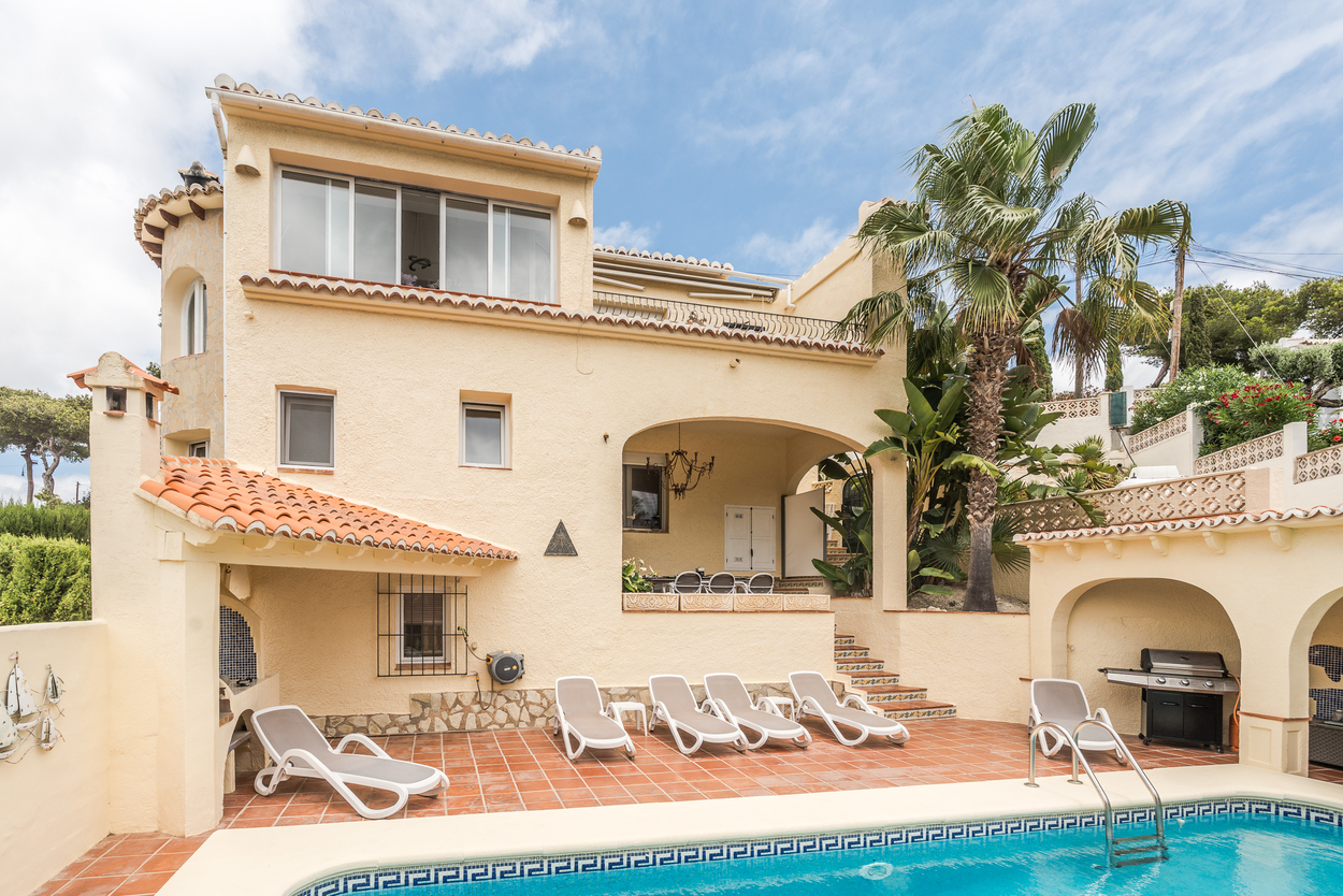 Extérieur de la villa orientée plein sud avec piscine de 8x4m, terrasse en terre cuite, chaises longues et une naya couverte à côté de l'espace barbecue.