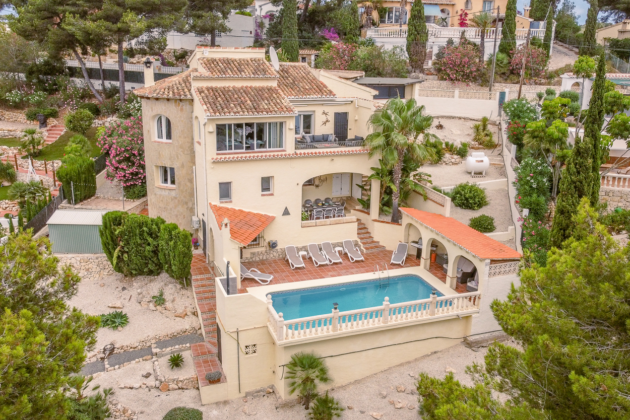Vue aérienne de la villa orientée sud avec piscine 8x4m, terrasse en terre cuite et plusieurs nayas couvertes intégrées à l'architecture méditerranéenne à plusieurs niveaux.