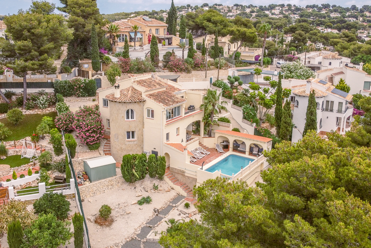 Vue aérienne de la villa orientée sud avec tour en pierre, terrasses à plusieurs niveaux et piscine 8x4m avec espace barbecue couvert et solarium.