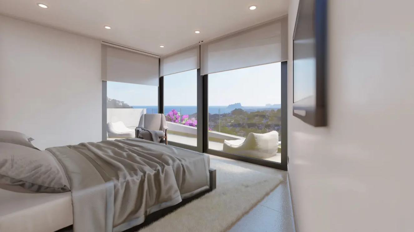 Chambre moderne avec baies vitrées toute hauteur offrant une vue panoramique sur la Méditerranée et le Peñón de Ifach, incluant un accès terrasse.