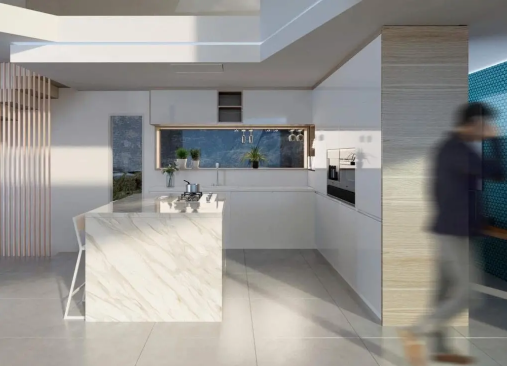 Cuisine moderne avec îlot en marbre, plaque de cuisson intégrée et meubles blancs épurés. Une fenêtre panoramique sert de crédence sous les éléments de rangement.