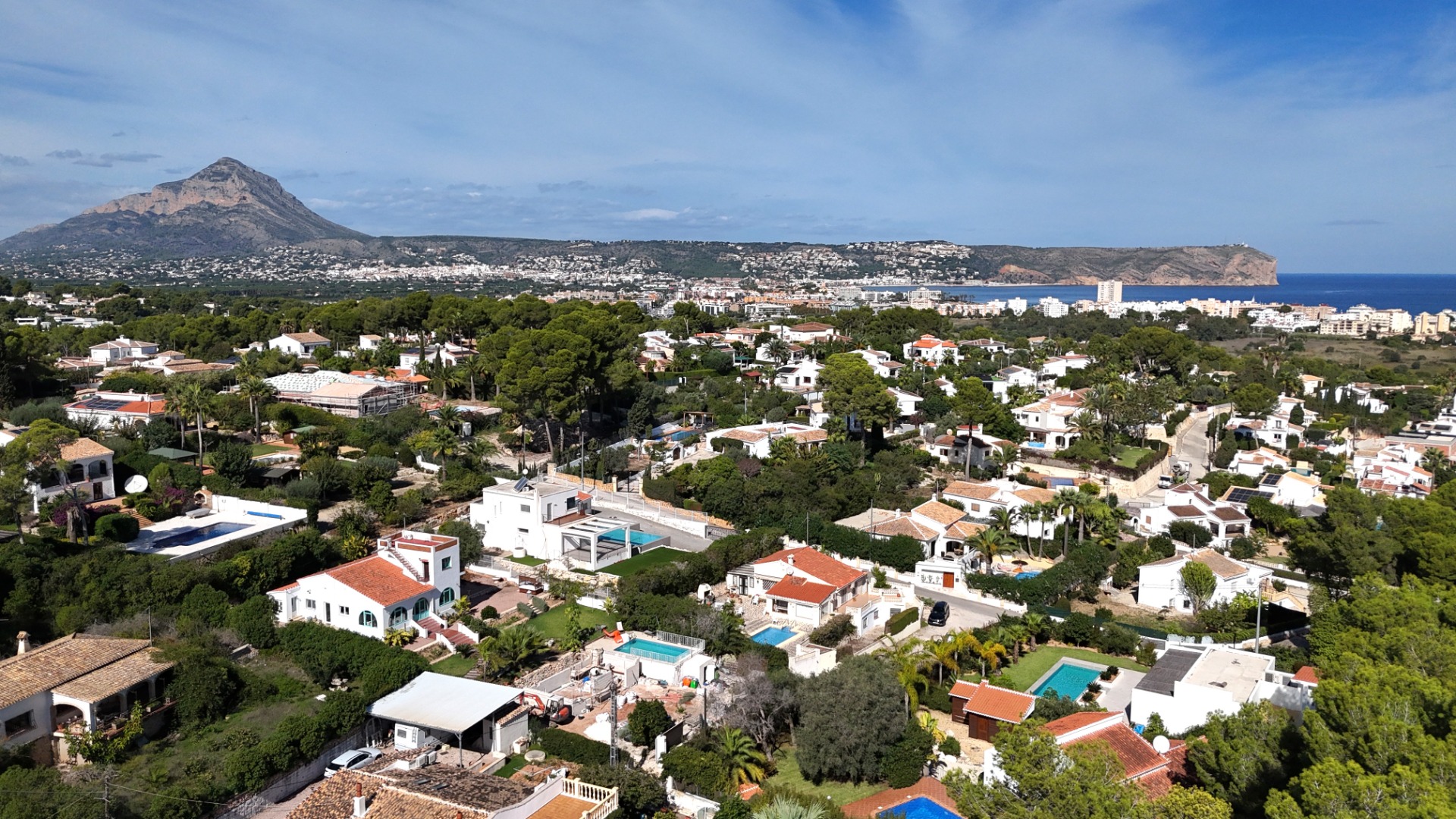 Vue aérienne panoramique du quartier de Toscal à Jávea, mettant en valeur le Montgó, le Cabo San Antonio et le littoral méditerranéen par temps clair.