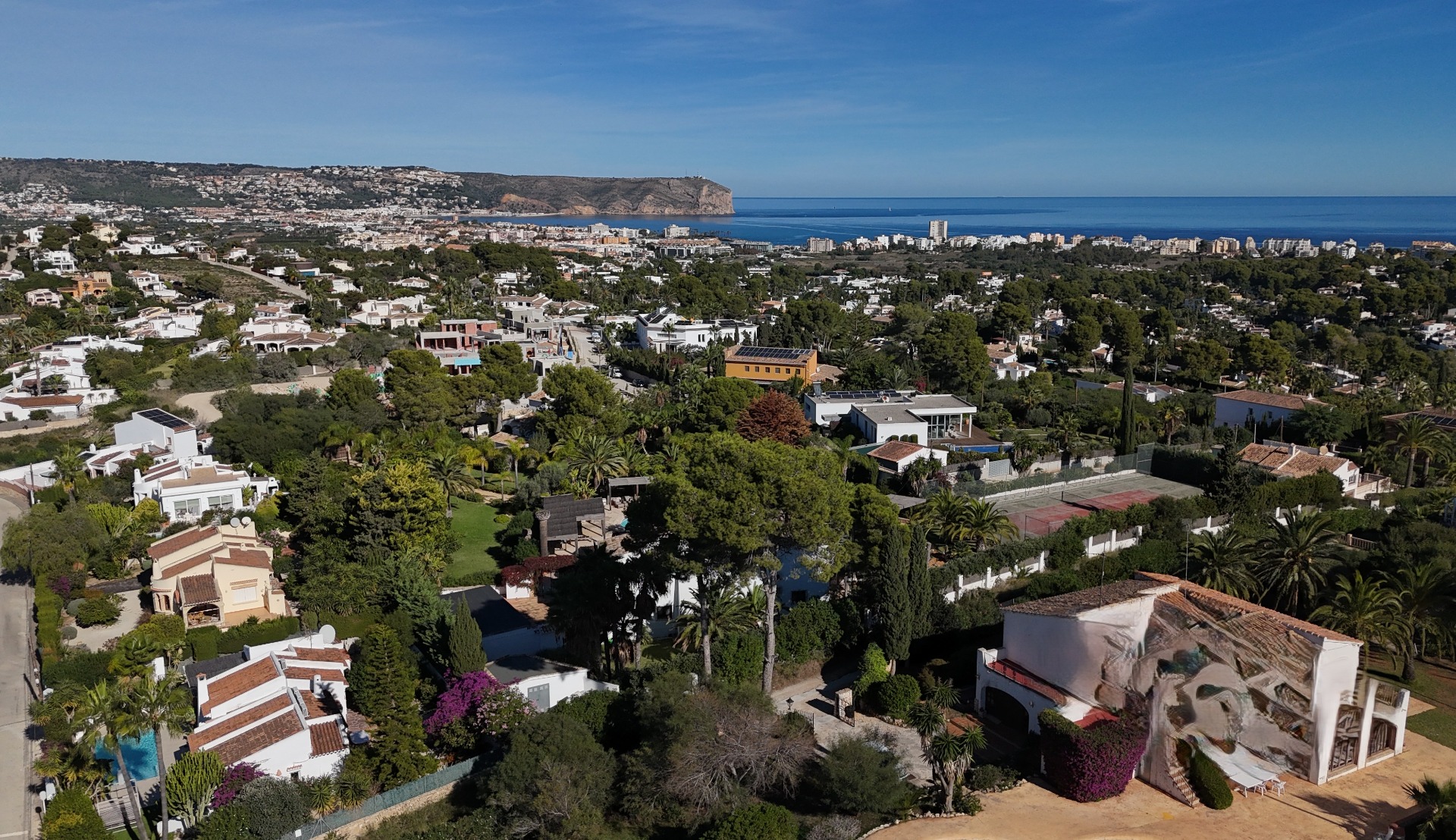 Vue aérienne panoramique du quartier de Pinosol à Jávea, révélant la proximité de la mer Méditerranée et de l'emblématique Cap San Antonio.