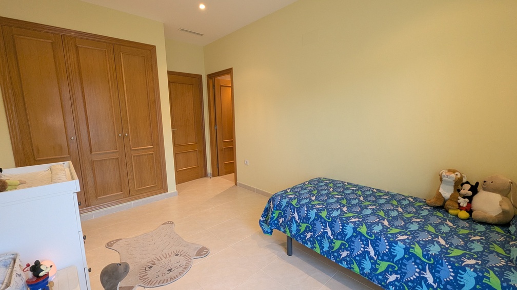 Chambre d'enfant comprenant une armoire intégrée en bois à quatre portes, un sol en carrelage et une climatisation par conduits.