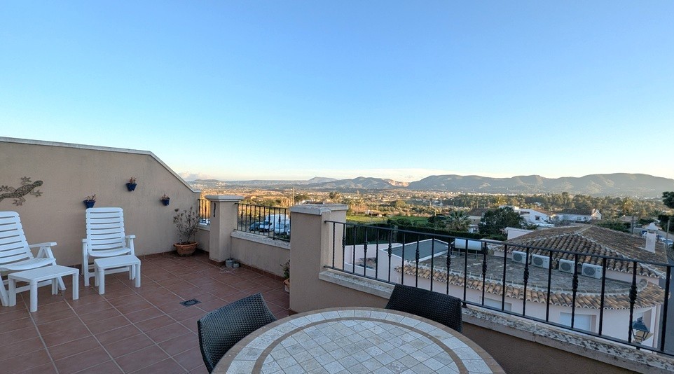 Grande terrasse sur le toit avec carrelage en terre cuite, coin repas extérieur et vues panoramiques sur la vallée et les montagnes environnantes.