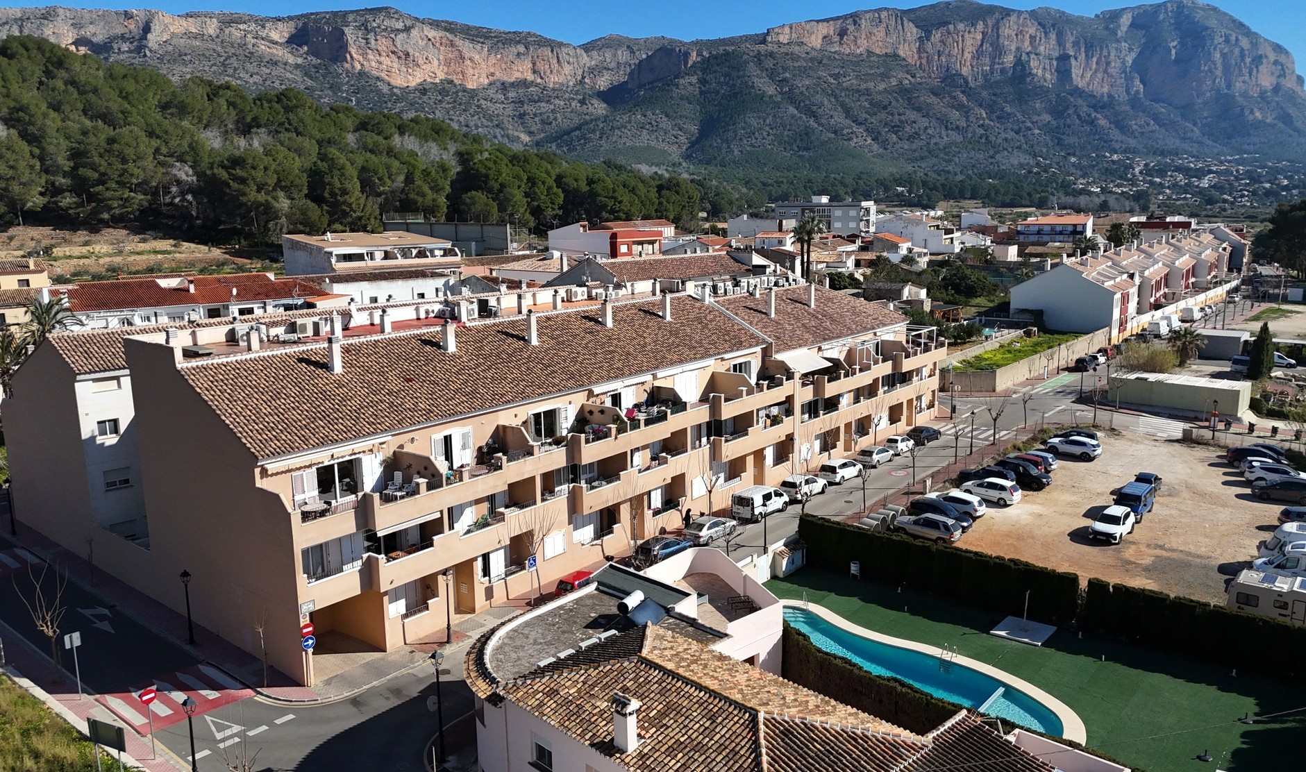 Vue aérienne du complexe à Jesús Pobre, montrant la piscine commune, les toits en terre cuite et le panorama sur la montagne du Montgó.