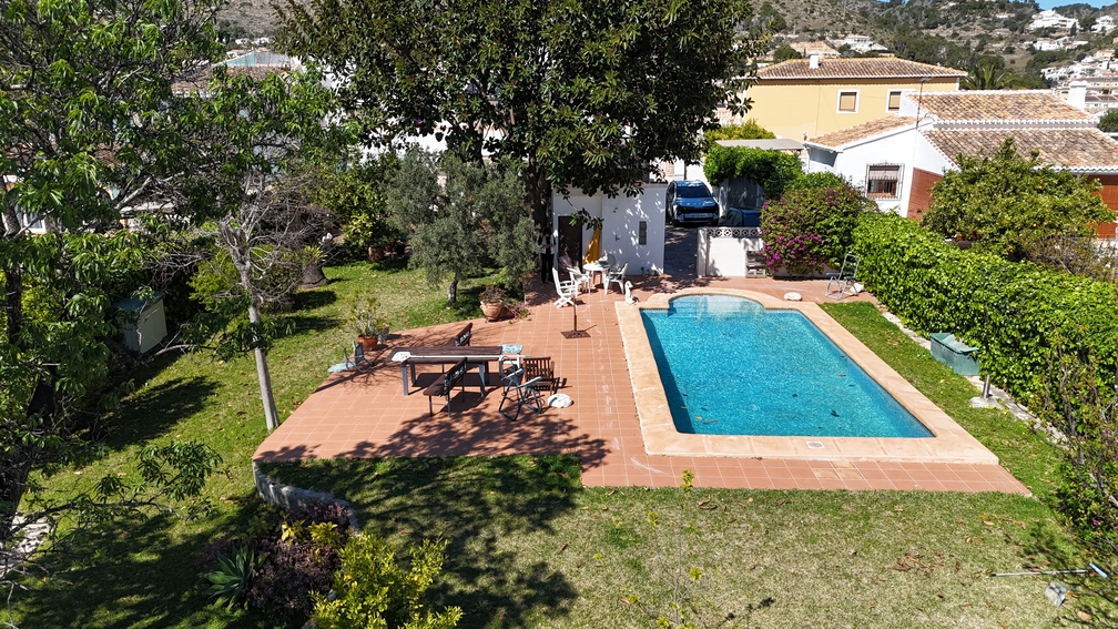 Piscine privée avec terrasse en terre cuite et pelouse. Des arbres matures et des haies assurent l'intimité de l'espace repas extérieur et du jardin.