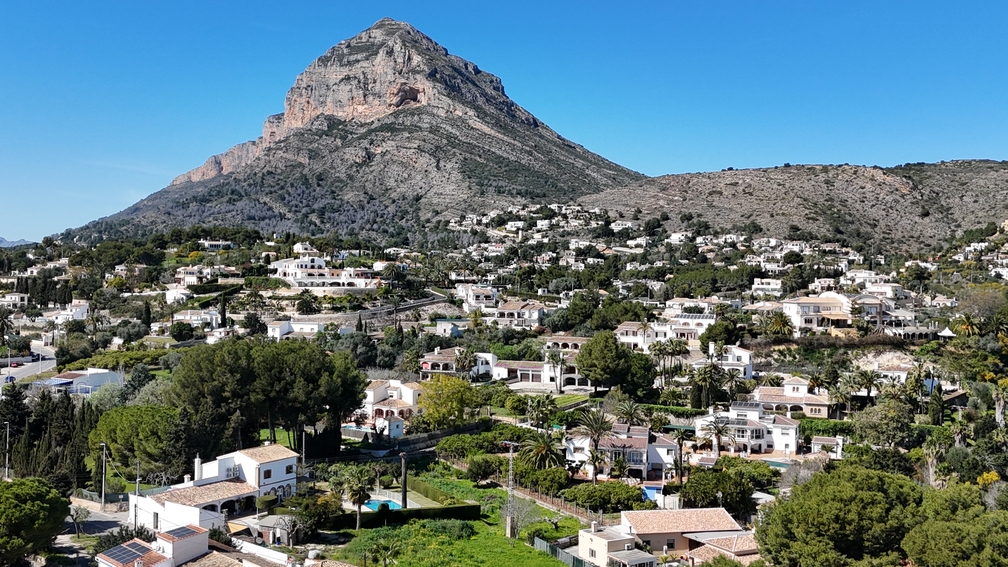 Vue panoramique sur le massif du Montgó dominant le paysage résidentiel de Javea, avec ses villas blanches traditionnelles et sa végétation méditerranéenne.