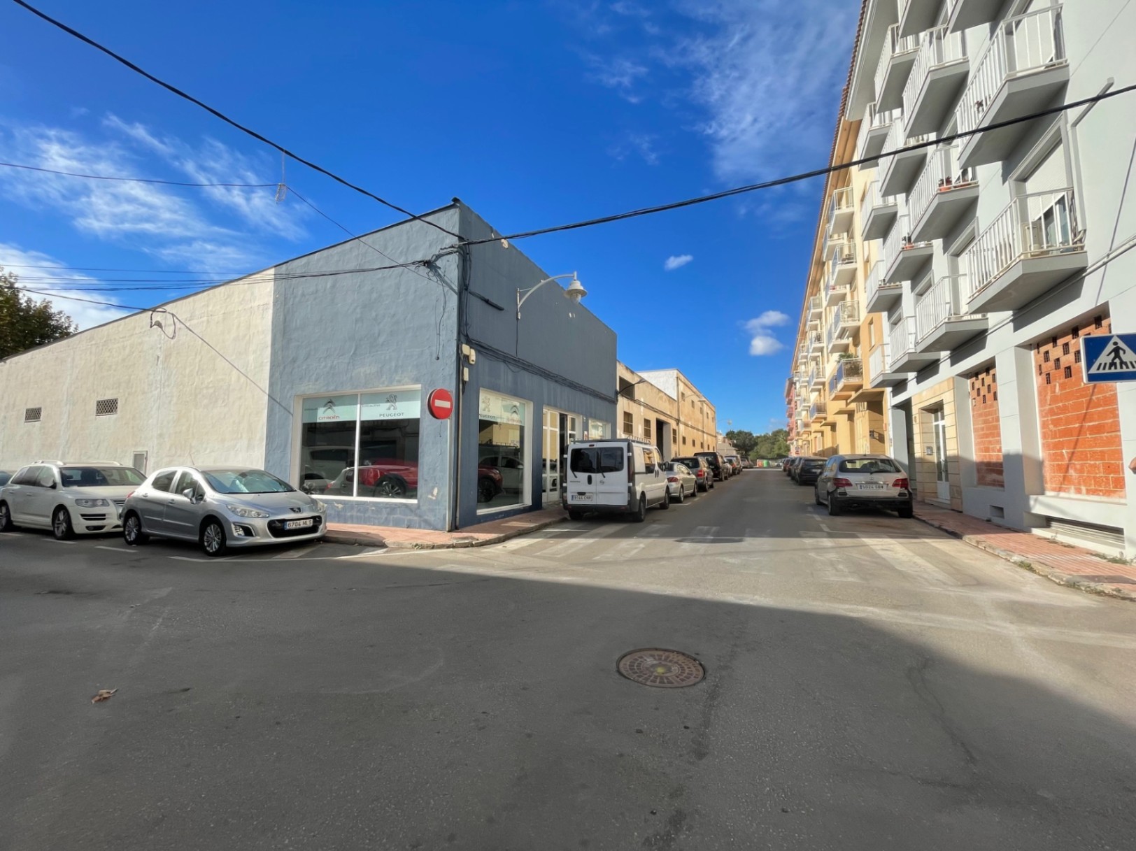 Vue extérieure de l'angle du local commercial, avec de grandes vitrines et un accès direct depuis la rue dans un quartier animé de Jávea.