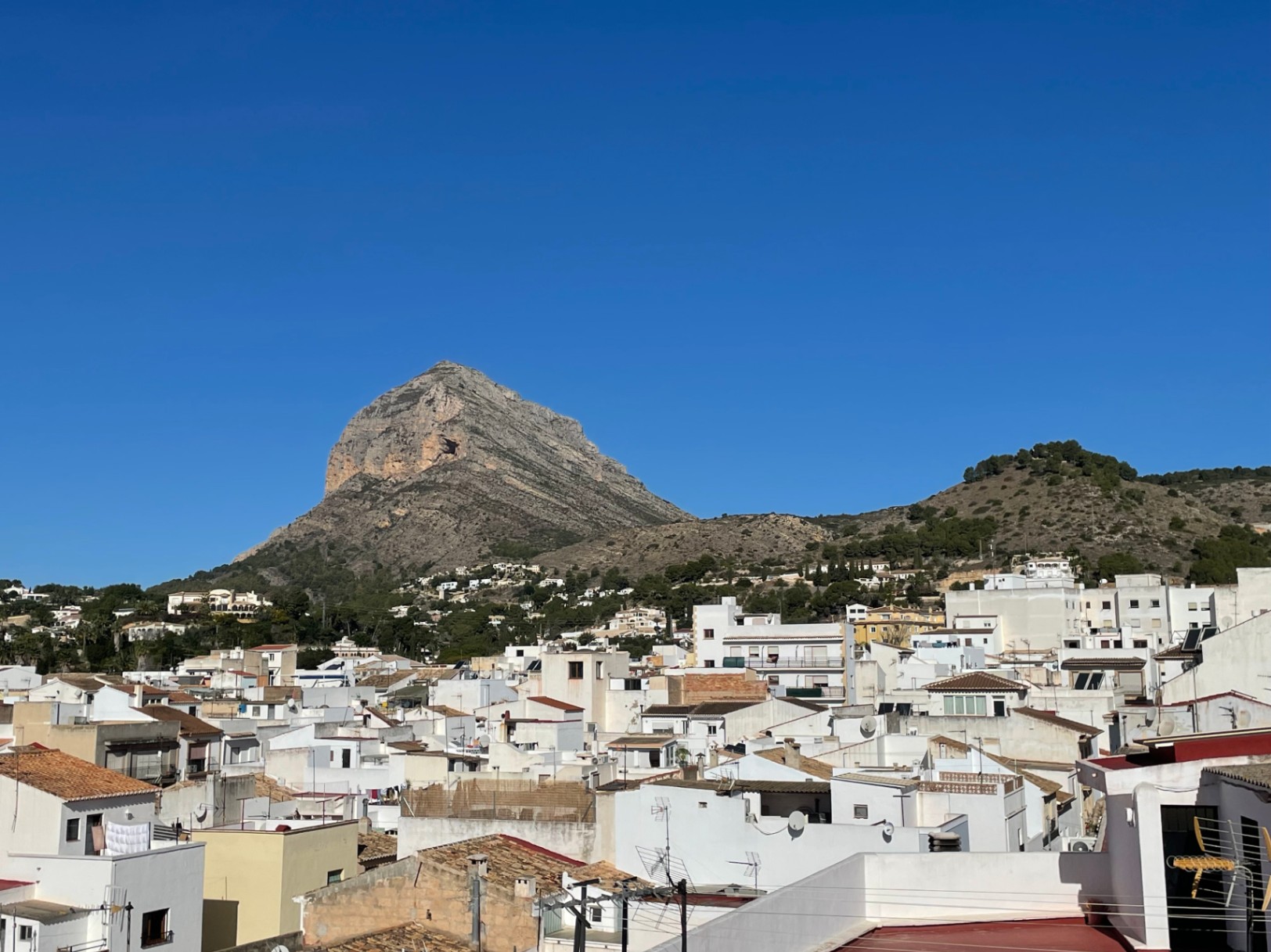 Vues panoramiques depuis le toit-terrasse sur le mont Montgó et le centre historique de Jávea, avec ses maisons blanches traditionnelles et ses toits en tuiles.