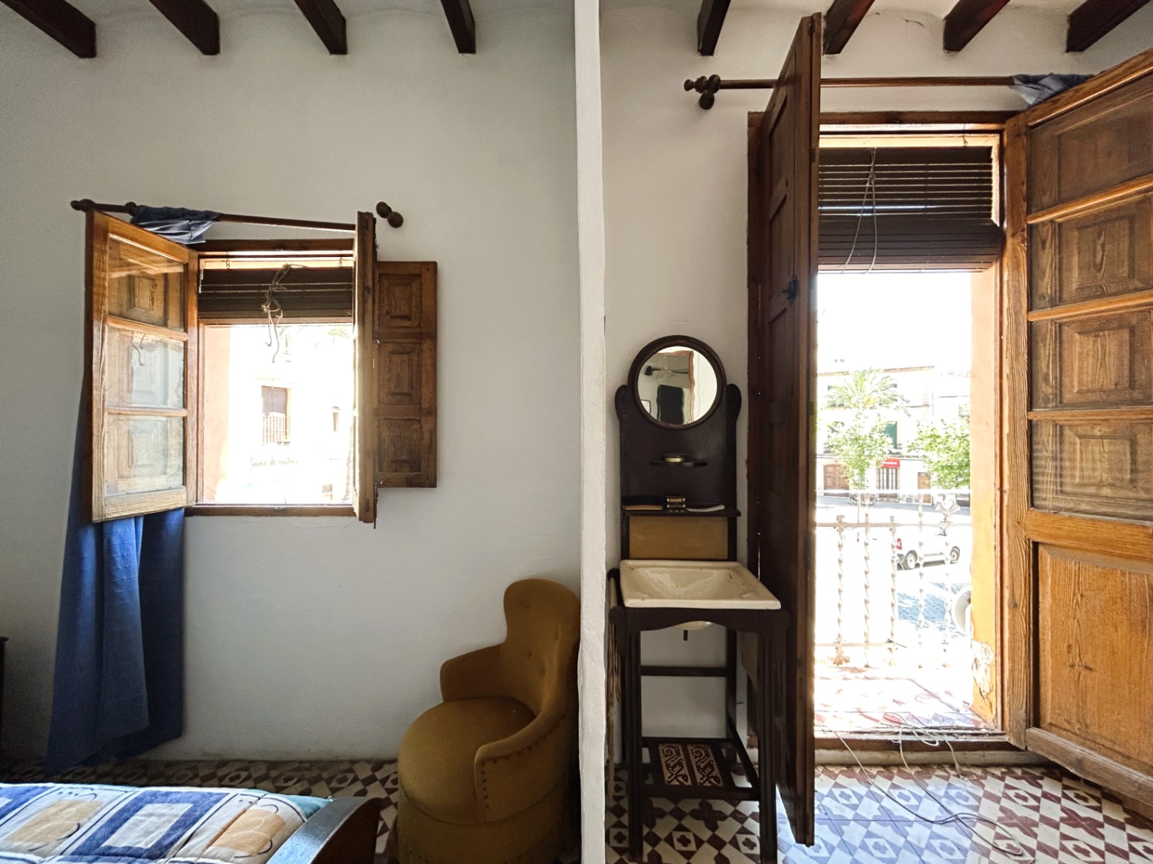 Chambre traditionnelle avec poutres apparentes, sol en carreaux de ciment d'origine et balcon donnant sur la vieille ville de Jávea. Comprend un lavabo vintage.