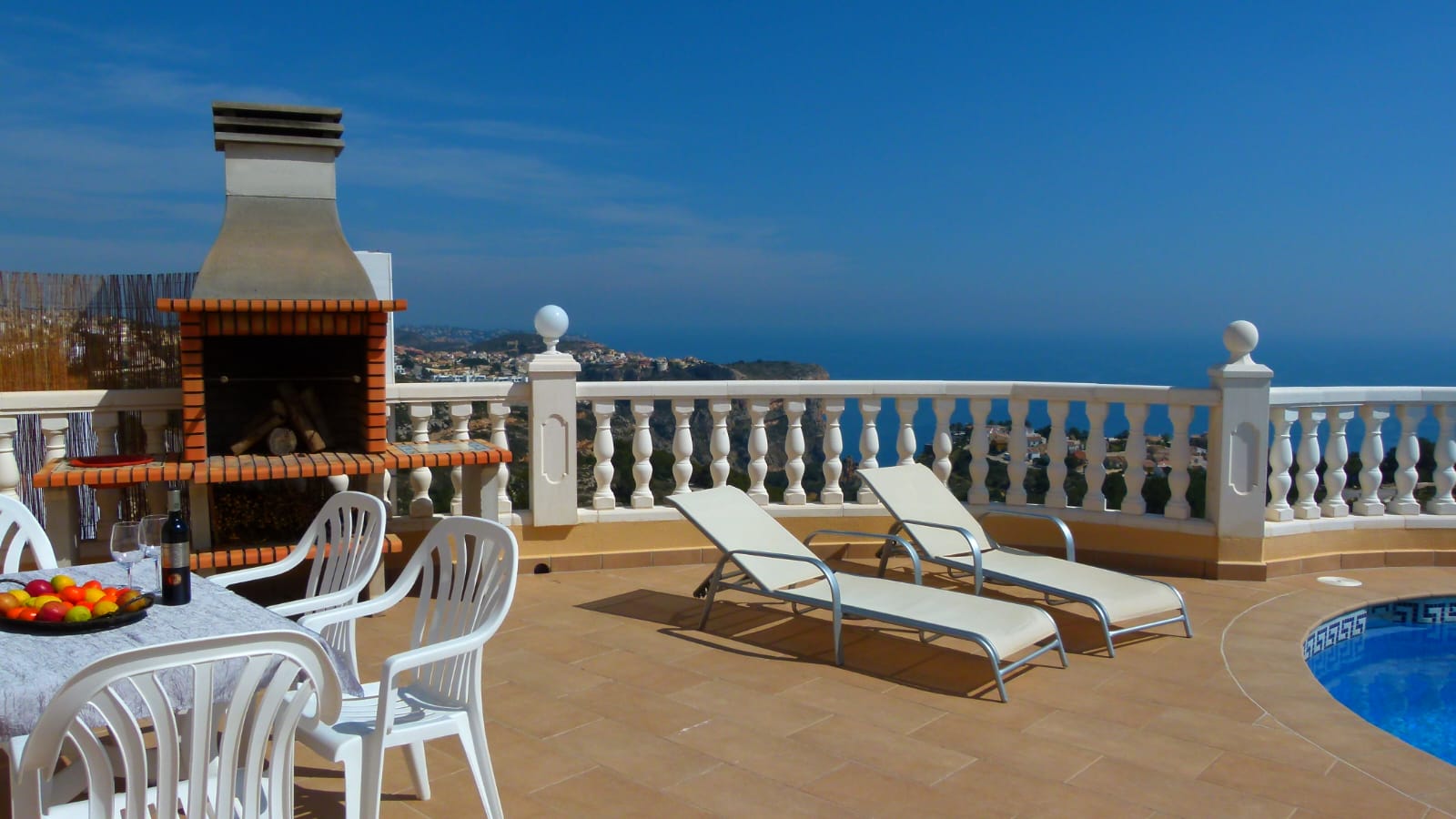 Terrasse avec barbecue en brique, transats et vue sur la mer depuis Cumbre del Sol, Benitachell.