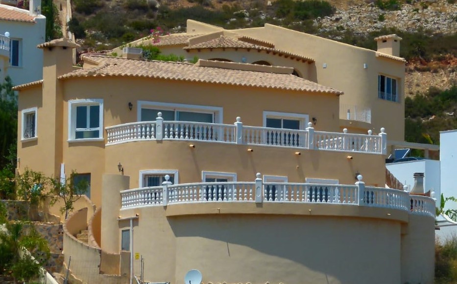 Vue extérieure de la villa avec balcons courbes et balustrades blanches à Cumbre del Sol.
