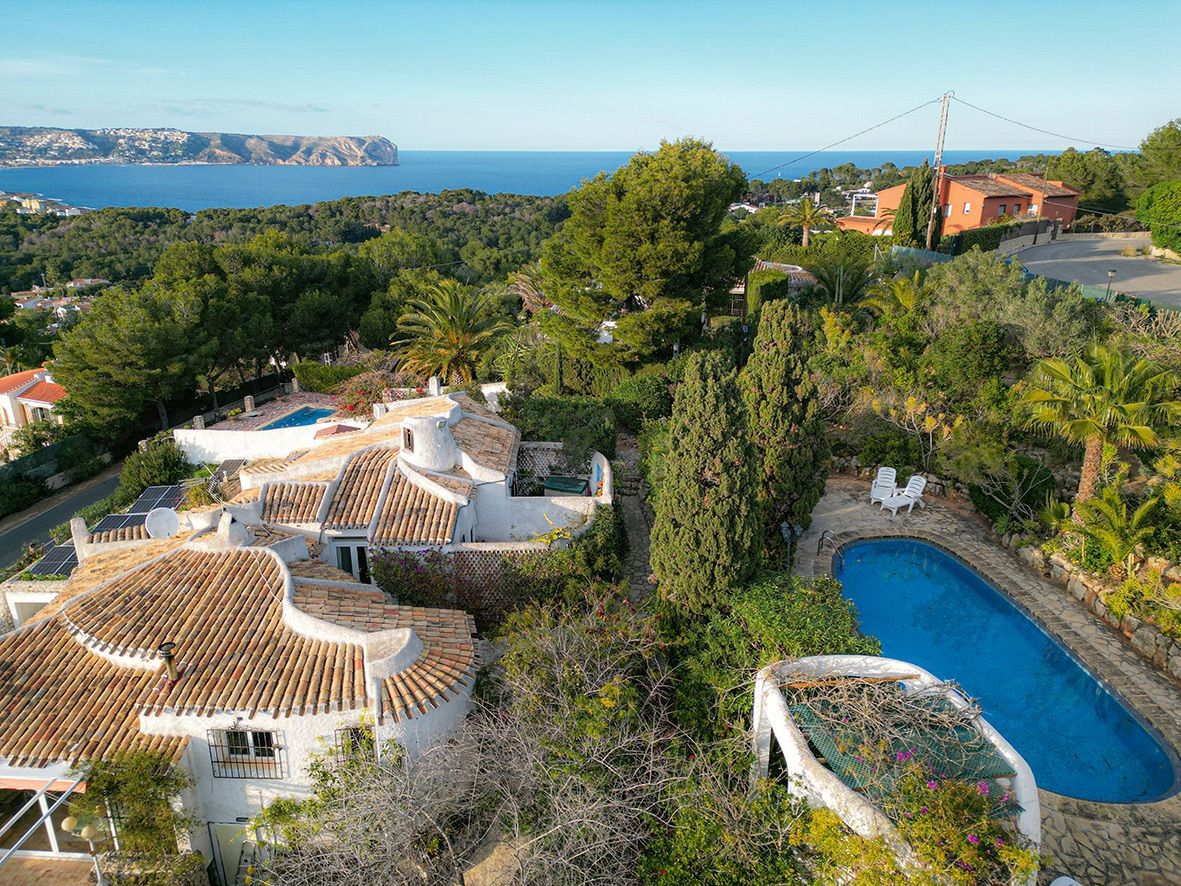 Vue aérienne de la villa traditionnelle avec ses toits en tuiles romaines, sa piscine privée et une vue panoramique imprenable sur la mer Méditerranée.