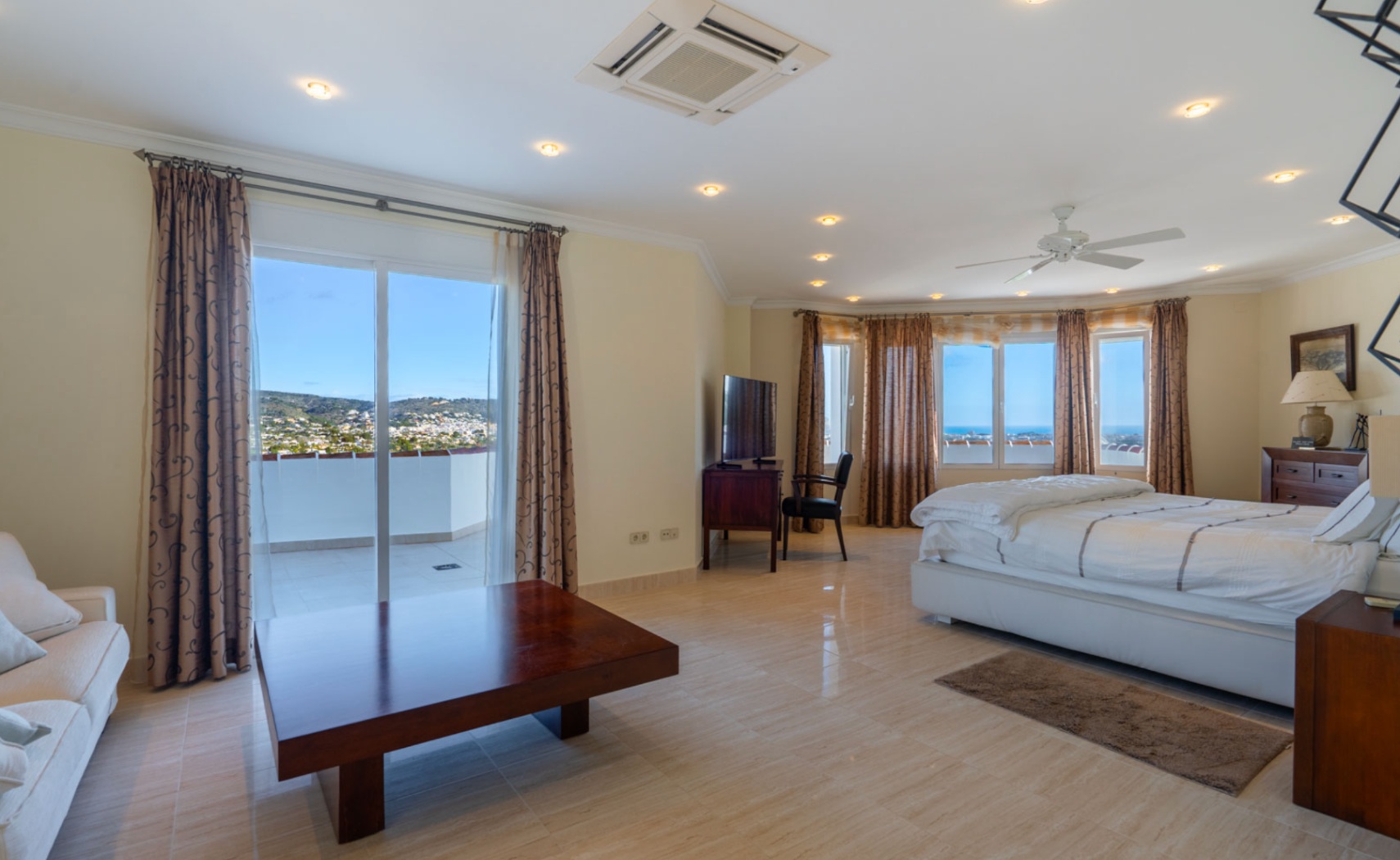Suite parentale avec accès direct à une terrasse privée offrant des vues sur la mer. Comprend un sol en grès poli, la climatisation intégrée et un éclairage encastré au plafond.
